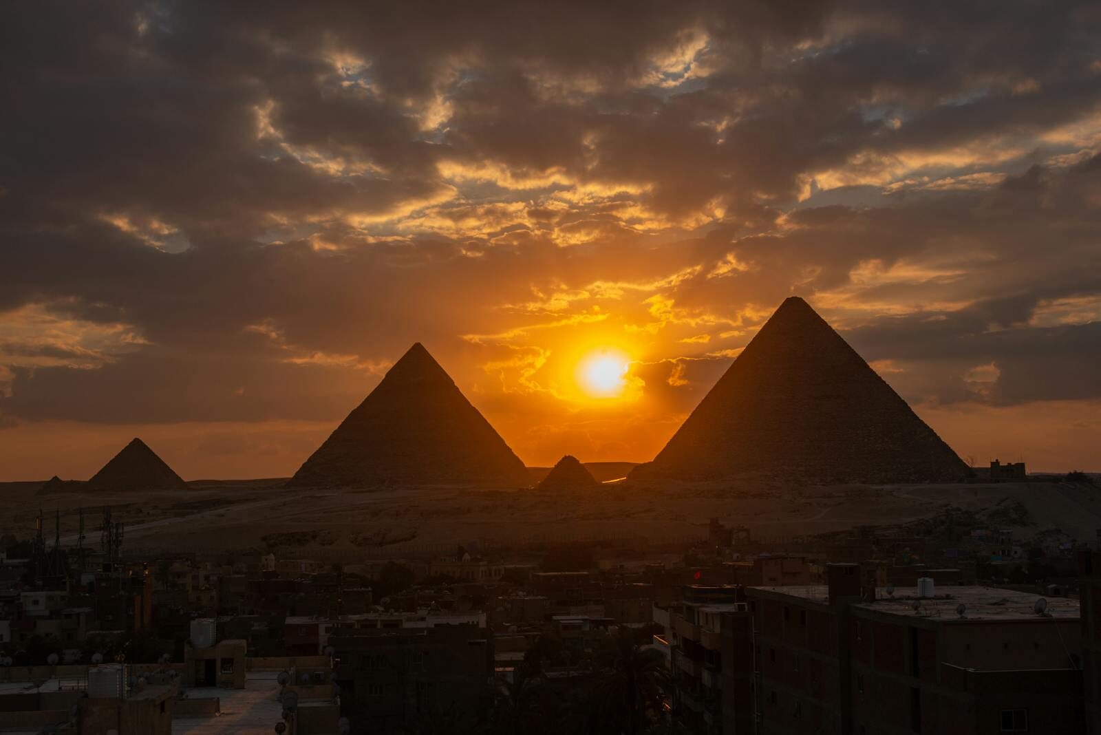 Silhouette of the Giza pyramids at sunset, capturing dramatic skies and ancient wonder.
